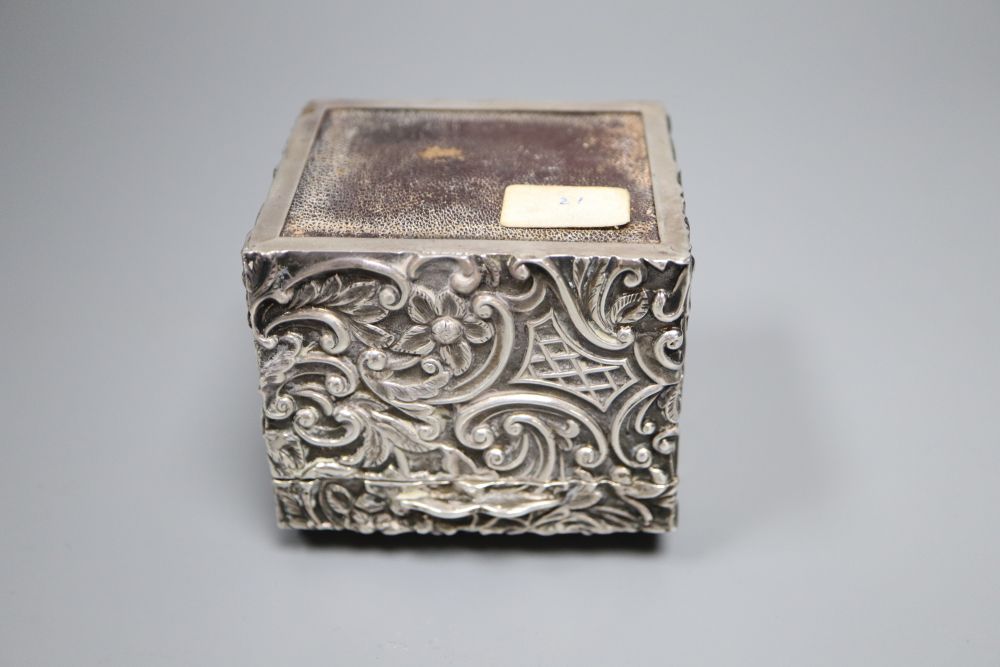 A late Victorian embossed silver serviette ring box, containing two serviette rings, Henry Matthews, Birmingham, 1892